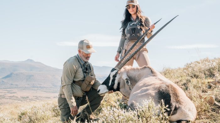 Female hunter with oryx trophy and professional guide in Eastern Cape mountains documented by Wildsmith for Tollies African Safaris