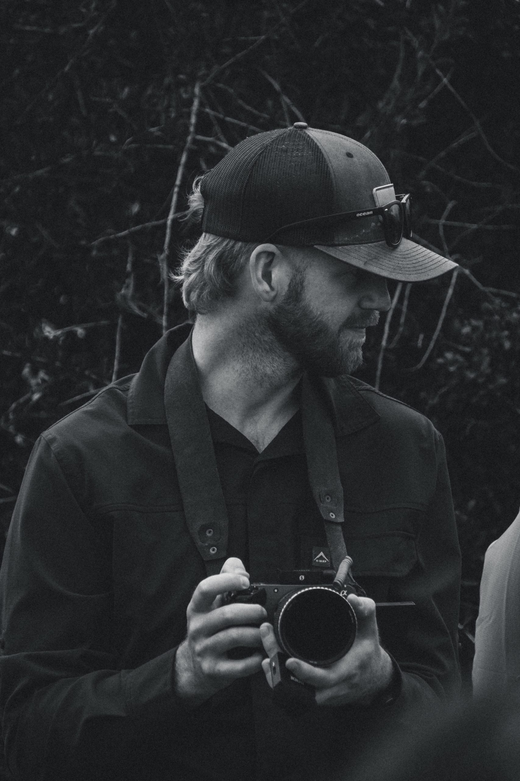 Professional safari videographer Andy from Wildsmith team holding Sony camera equipment in black and white portrait